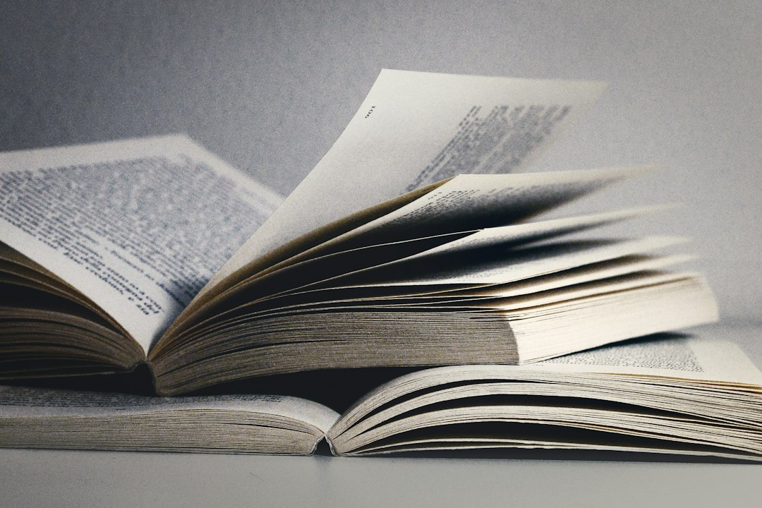 Two open books with pages flipping, suggesting study and research